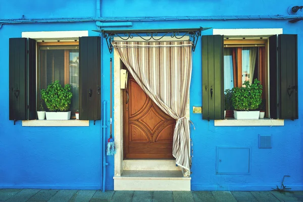 Front of the blue house on the island of Burano. Italy, Venice. Toned