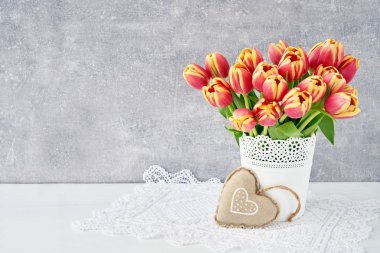 Beyaz vazoda kırmızı lale buketi Tekstil kalp ile dekore edilmiştir. Sevgililer günü, anneler günü, doğum günü kavramı. Kopya alanı                               