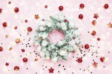 Noel arkaplanı. Pembe arka planda Noel çelengi. Boşluğu kopyala, üst görünüm.