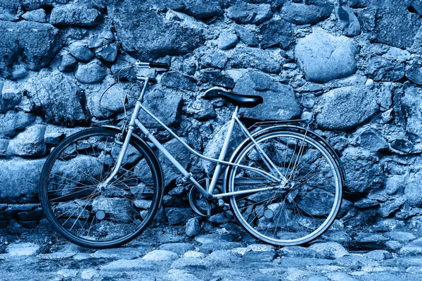 Velha bicicleta enferrujada azul contra a velha parede da rua. Cor do ano 2020 clássico azul tonificado . — Fotografia de Stock