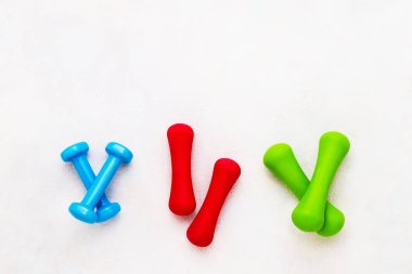 Beton arka planda renkli dambıllar var. Sağlıklı yaşam tarzı kavramı. Metin için boşluk kopyala, üst görünüm