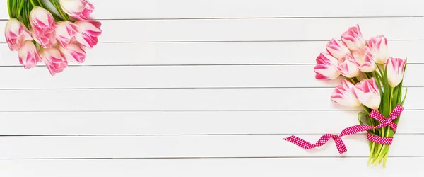 Sträuße von rosa Tulpen auf weißem Holzgrund. Kopierraum, Draufsicht. Geburtstag, Muttertag, Valentinstag. Banner — Stockfoto