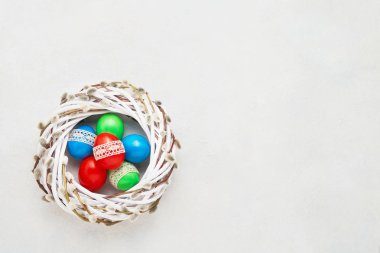 Paskalya geçmişi. Beyaz arka planda dantelle süslenmiş renkli Paskalya yumurtaları. Üst görünüm, metin için boşluk kopyala