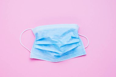 Pembe arka planda tıbbi koruyucu maske. Sağlık ve tıbbi konsept. Üst görünüm, metin için boşluk kopyala