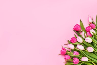 Pembe arka planda bir buket pembe lale. Anneler günü, sevgililer günü, doğum günü kutlaması konsepti. Tebrik kartı. Metin için boşluk kopyala, üst görünüm