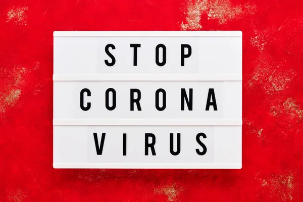 STOP CORONA VIRUS written in light box on red background. Health care and medical concept. Top view. Quarantine concept.