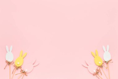Paskalya süsü. Pembe arka planda renkli ahşap Paskalya yumurtaları. Tebrik kartı. Üst görünüm, alanı kopyala