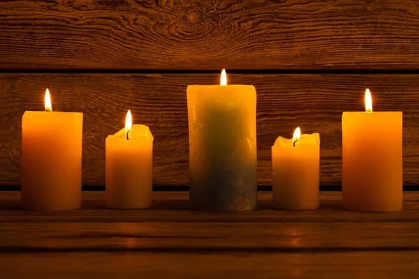 Kerzen in verschiedenen Größen auf dem Holzgrund. — Stockfoto