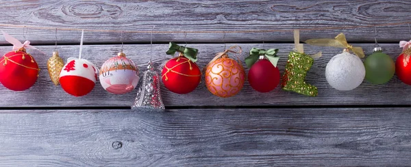 Christmas garland with different balls on a wooden background. — Stock Photo, Image