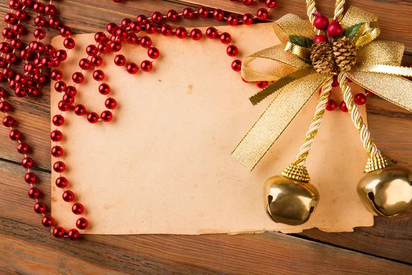 Vieux papier avec perles rouges et cloches de Noël . — Photo