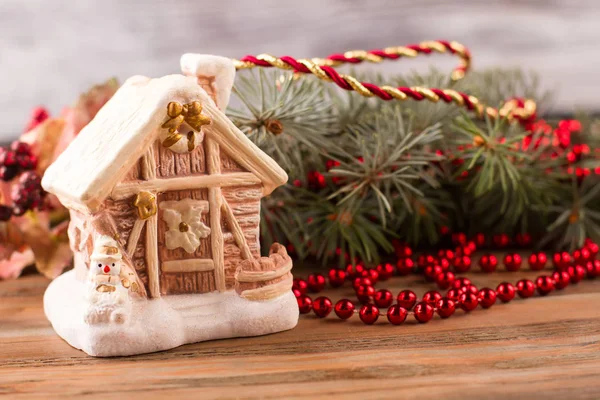 Söta hus med en snögubbe på en bakgrund av gröna träd. — Stockfoto