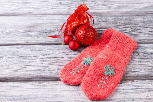 Růžové pletené palčáky a vánoční ozdoby. — Stock fotografie