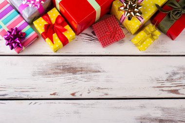 Güzel bir ahşap arka plan üzerinde Paketli birçok renkli hediyeler. 