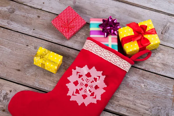 Gifts near red Christmas socks. — Stock Photo, Image