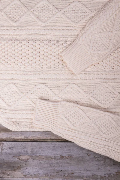 Dettaglio di maglione bianco lavorato a maglia su tavole vintage . — Foto Stock