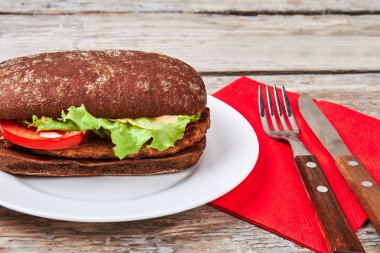 Çatal bıçak takımı hamburger yakınındaki peçete üzerinde.