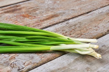 Ahşap zemin üzerine yeşil soğan.