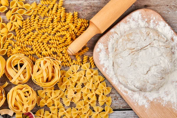 Close-up of pasta with different dough and rolling pin.