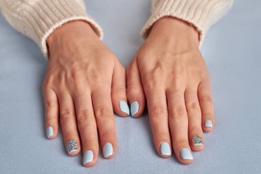 Kumaş arka plan üzerinde hassas mavi manikür. 