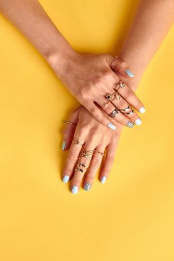 Manikürlü parmaklar üzerinde çok altın yüzük.