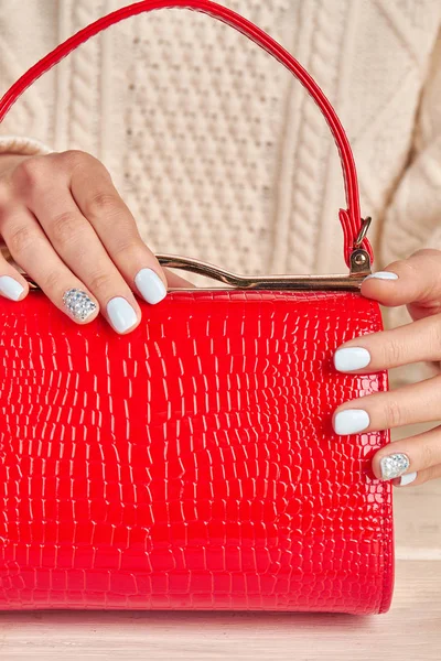 Primo piano di borsa femminile rossa e manicure . — Foto Stock