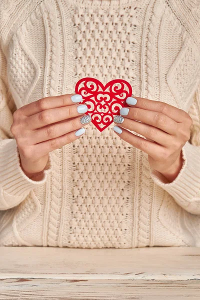 Le unghie di donne azzurre con un strass tengono il cuore rosso . — Foto Stock