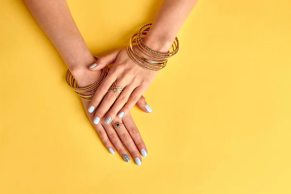 Many beautiful gold rings and bracelets on the women's hands. — Stock Photo, Image