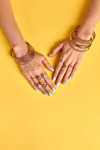 Beautiful summer gold bijouterie on female hands. — Stock Photo, Image