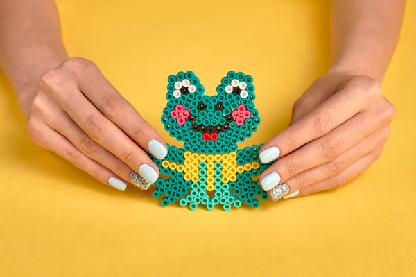 Cute toy frog in female hands.