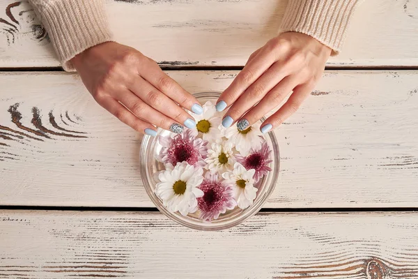 Belle mani femminili con manicure e fiori vista dall'alto . — Foto Stock