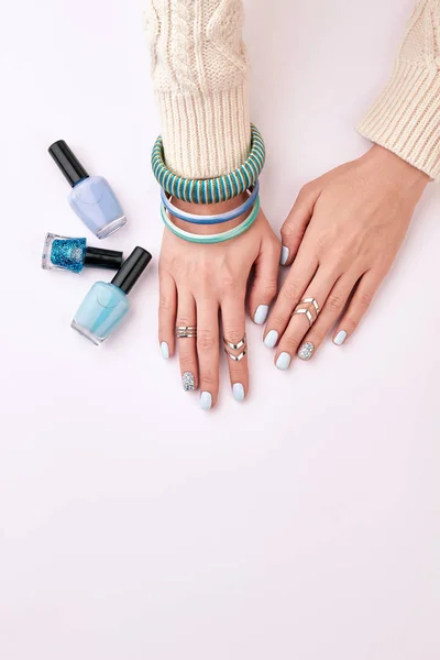 Blue manicure and correctly selected bijouterie.