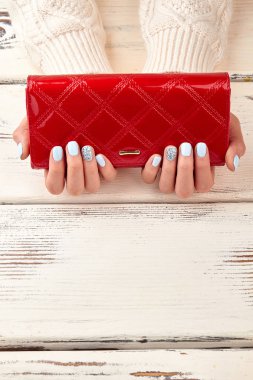 Kırmızı debriyaj ve ahşap zemin üzerine mavi manikür.