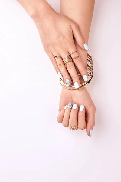 Beautiful female hands in gold bracelets and rings. — Stock Photo, Image