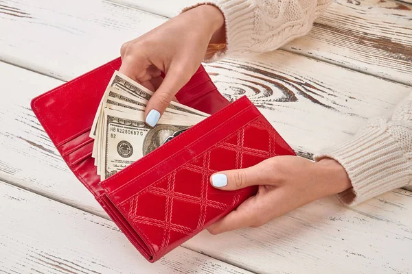 Bolsa vermelha com dólares nas mãos . — Fotografia de Stock