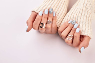 Gümüş Yüzük ve mavi manikür ile el. 