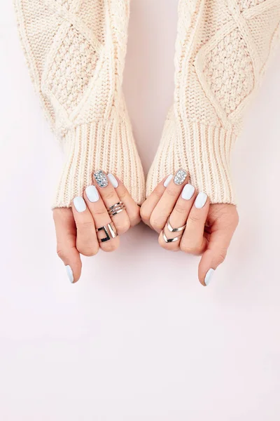 Manos femeninas con anillos plateados y manicura azul . — Foto de Stock