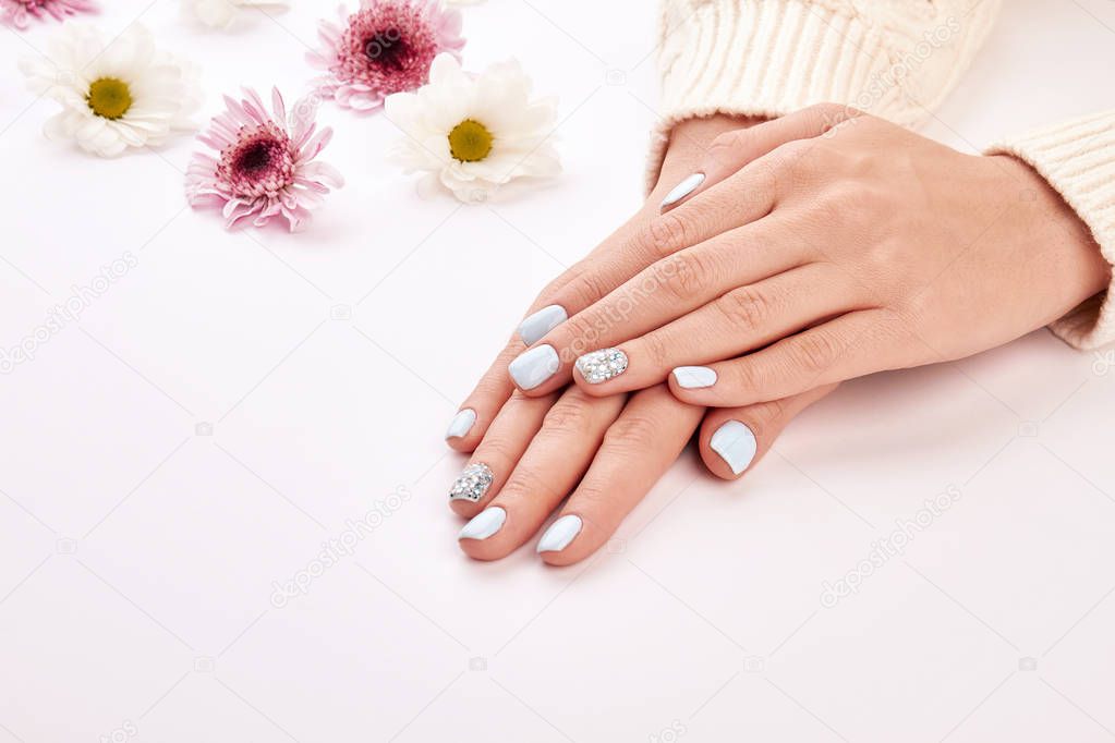 Delicate woman's manicure on a white background. 