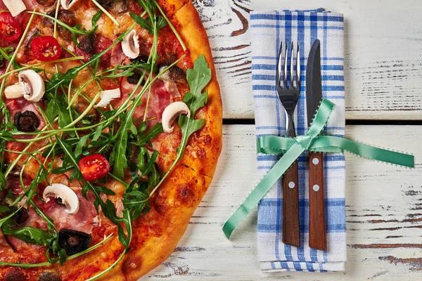 Close up of pizza and cutlery.