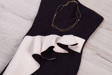 Siyah ve beyaz elbise ile altın takı. 