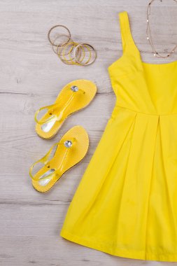 Sandalet ve mücevherat ile sarı elbise. 