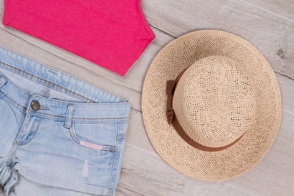 Růžový top, džínové šortky a slaměný klobouk. — Stock fotografie