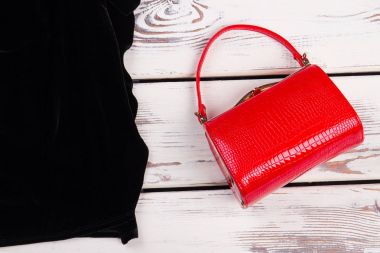 Kırmızı el çantası debriyaj, siyah elbise.