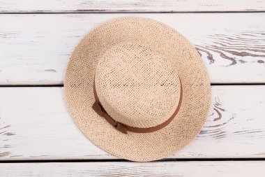 Ahşap arka plan üzerinde dokuma şapka.
