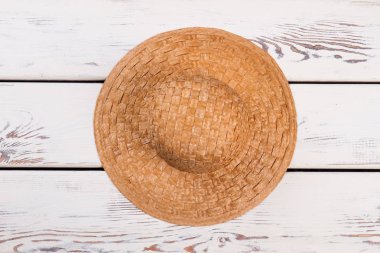 Hasır şapka ahşap arka planda.