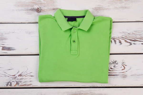 Camisa verde sobre fundo de madeira . — Fotografia de Stock