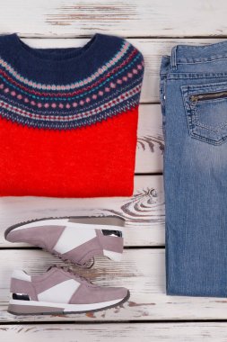 Jumper, düzenli kot pantolon ve spor ayakkabı