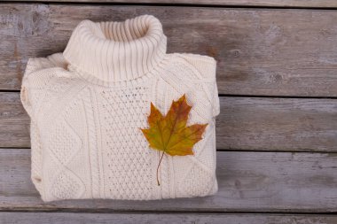 Beyaz kazak ve akçaağaç yaprağı