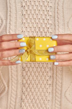 Kadının elinde sarı kutu