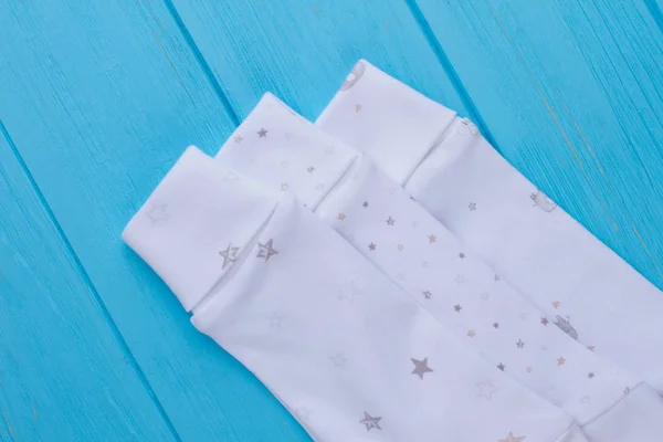Close up sleeves of white baby sleepers.