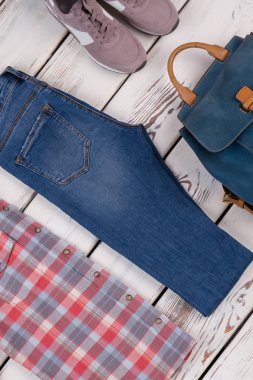 Gömlek, kot pantolon, spor ayakkabılar ve sırt çantası